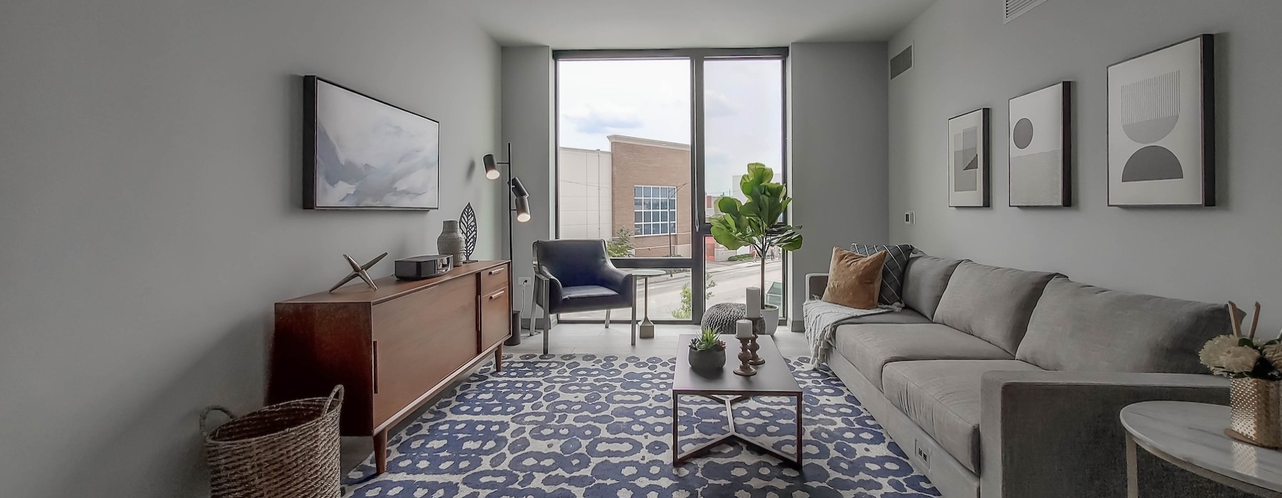 a living room with a large window, a couch and a coffee table