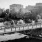a black and white photo of a park with a fence and trees