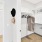 a closet with white shelves, hangers and a washer and dryer in the background