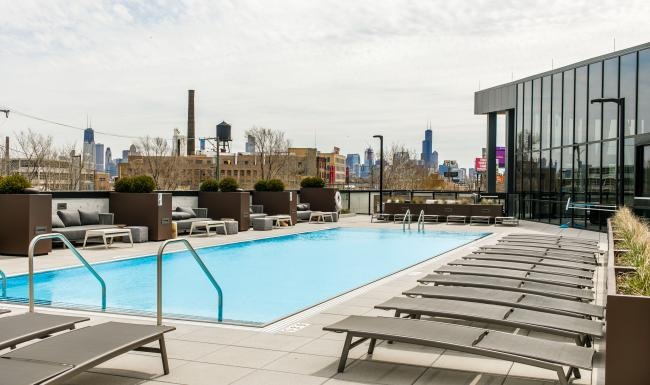 a pool with a deck and benches by it